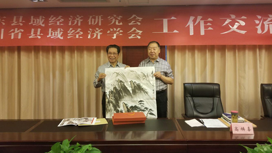 山樂縣域經(jīng)濟研究會會長高煥喜向四川省縣域經(jīng)濟學會會長張成明贈送書畫作品.jpg
