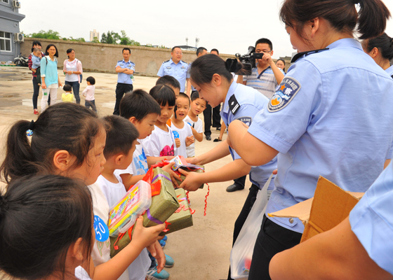 圖為民警為兒童發(fā)“六一”生日禮物.JPG