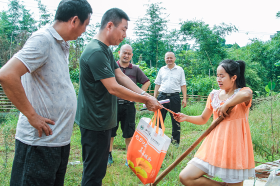 江安農(nóng)商銀行黨委書記王勇(左二)給結(jié)對(duì)幫扶貧困戶送去慰問品和慰問金.jpg
