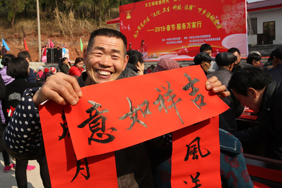 內(nèi)江春節(jié)到來(lái)時(shí)政府開(kāi)展送文化下鄉(xiāng)活動(dòng)，一村民拿到新寫就的春聯(lián)喜笑顏開(kāi) 蘭自濤 攝.JPG