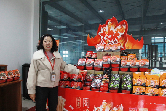 錦膳食品的工作人員向記者介紹即食燃面產品.JPG