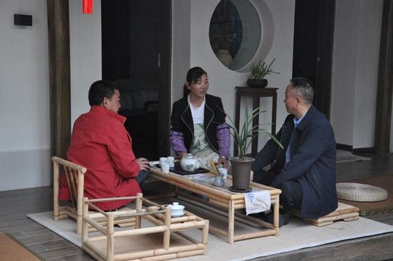 “樹舍”民宿管理員小王（中）向當(dāng)?shù)馗刹亢陀浾呓榻B經(jīng)營(yíng)情況  潘興揚(yáng) 攝.JPG