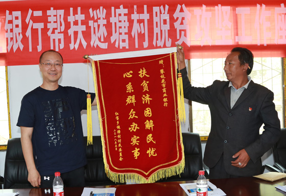 攀枝花市商業(yè)銀行黨組書記、董事長楊宗林（左）接受結(jié)對扶貧鄉(xiāng)贈送錦旗。.JPG