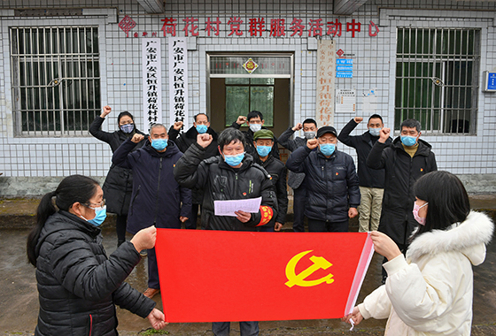 在疫情防控的關(guān)鍵時刻，2月4日，在入村勸導(dǎo)點前，四川省廣安市廣安區(qū)恒升鎮(zhèn)荷花村支部書記劉延春與全體黨員在鮮紅的黨旗前莊嚴宣誓  張國盛攝.JPG