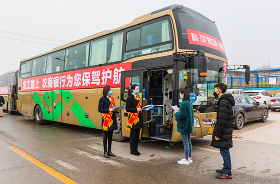 仁壽農(nóng)商銀行員工在農(nóng)民工返崗“春風行動”專車前向農(nóng)民工散發(fā)宣傳資料.png