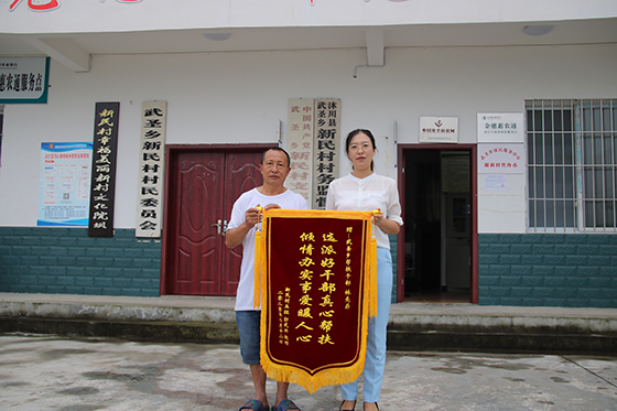 7月24日，四川沐川縣武圣鄉(xiāng)新民村脫貧戶郭武興來到村委會(huì)，將一面印有“選派好干部真心幫扶，傾情辦實(shí)事愛暖人心”的錦旗送到幫扶干部林先燕手中  崔前東 攝.JPG