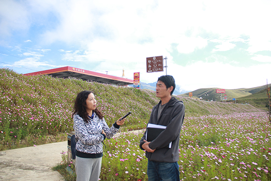 稻城縣林草局副局長(zhǎng)郭先劍（右）向記者介紹金珠濕地公園建設(shè)情況  周淼葭 攝.JPG