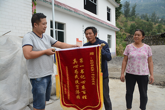 張遠(yuǎn)銀送錦旗給駐村第一書(shū)記李建榮  吳啟昌 攝.jpg
