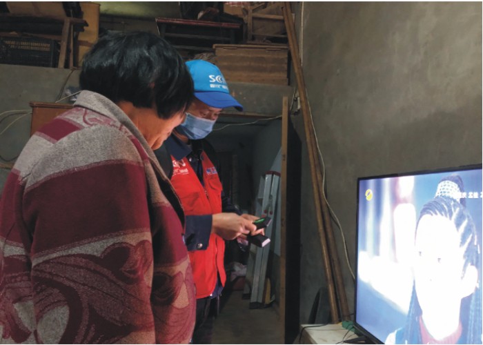 肖勇軍在給用戶送新遙控（樂(lè)至融媒記者 唐西蘭 攝）.jpg