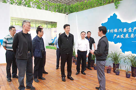 中藍(lán)農(nóng)業(yè)開發(fā)公司負(fù)責(zé)人詹富翔向四川省縣域經(jīng)濟(jì)學(xué)會(huì)調(diào)研組介紹酵素種植法  周淼葭 攝.JPG