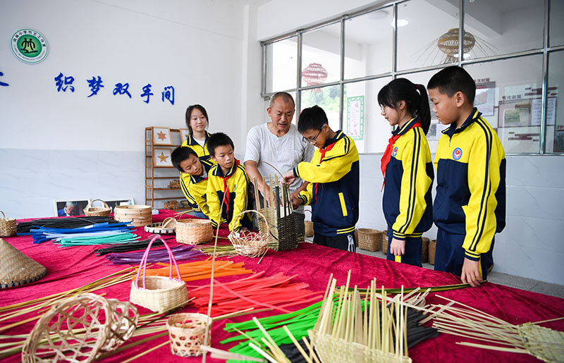 3、2022年7月20日，四川省瀘州市敘永縣向林鎮(zhèn)的留守兒童們?cè)谥窬巶鞒腥说闹笇?dǎo)下學(xué)習(xí)竹編技能。.jpg