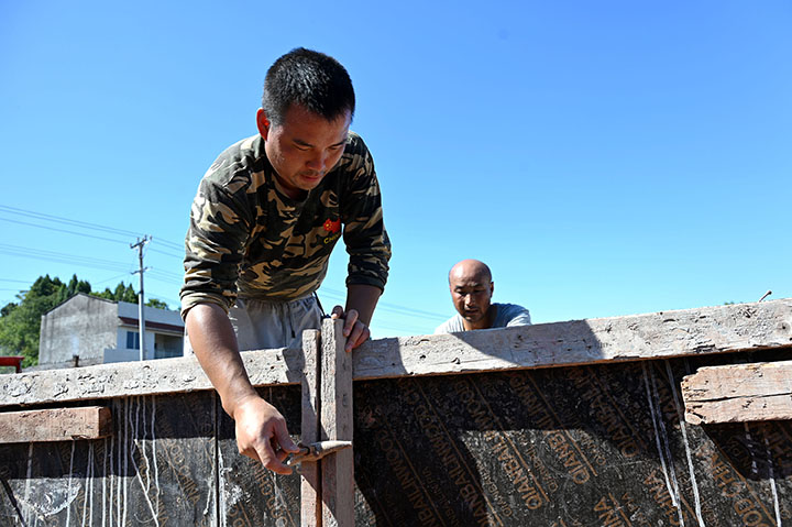 1660637178671759.jpg 3筑路工人正在為路沿澆筑架模.jpg