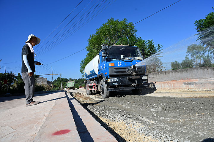 1660637184473311.jpg 4筑路工人在二灰鋪筑地段灑水.jpg