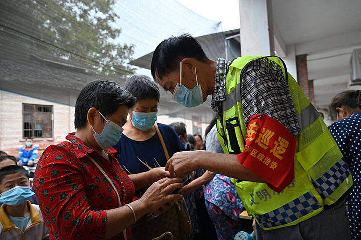 1661934693515154.jpg 1志愿者正在引導(dǎo)群眾按照疫情防控的要求查驗(yàn)健康碼、行程碼.jpg