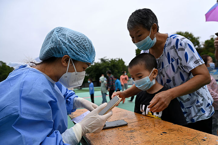 1661934698361717.jpg 2醫(yī)護(hù)人員和志愿者正在幫助師生掃健康碼登記信息.jpg