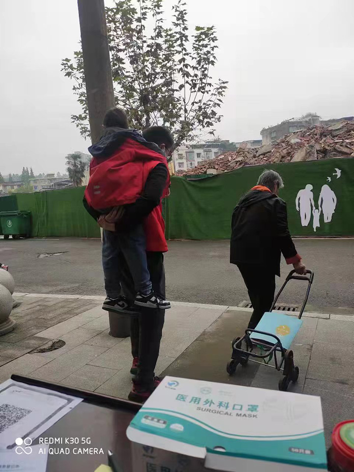 1665988717667006.jpg 2羅斌每天定時(shí)將小男孩背至檢測(cè)處做完核酸.jpg