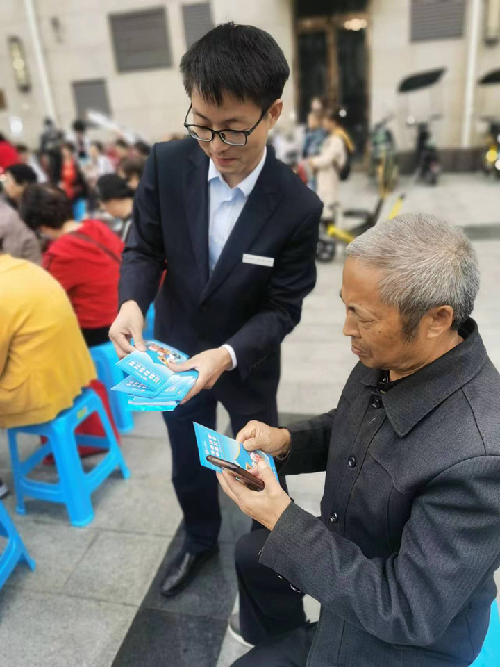 工作人員積極為老年群眾發(fā)放宣傳折頁(yè).jpg
