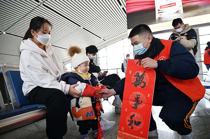 2志愿者為旅客送上具有濃郁年味特色的“?！倍Y.jpg