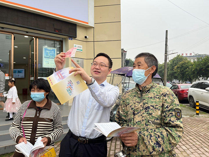6為客戶經(jīng)理正在為群眾介紹人民幣防偽特征.png