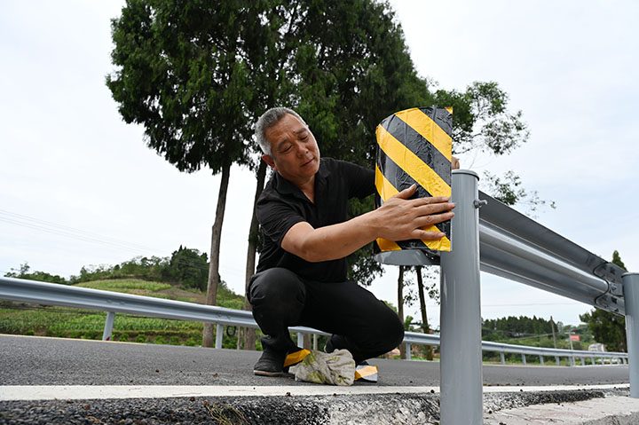 圖3  筑路工人正在加緊校正同福至新官山瀝青混凝土公路的安防設(shè)施.jpg