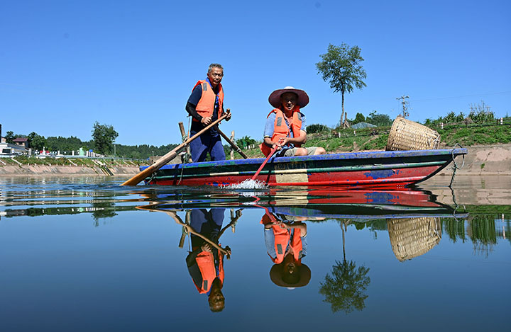 圖4  當?shù)厣鐓^(qū)居民在大清流河永福場鎮(zhèn)段水域駕船打撈漂浮物.jpg
