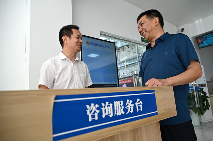 圖2  咨詢(xún)臺(tái)工作人員為辦事群眾那個(gè)解疑釋惑.png