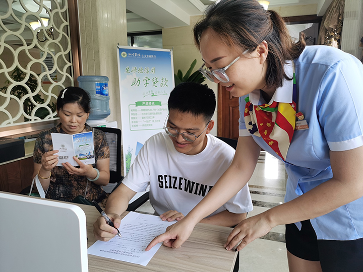 1696655067173166.jpg 仁壽農(nóng)商銀行濱河路支行工作人員細(xì)心指導(dǎo)學(xué)生填寫(xiě)助學(xué)貸款相關(guān)資料 仁壽農(nóng)商銀行供圖.jpg