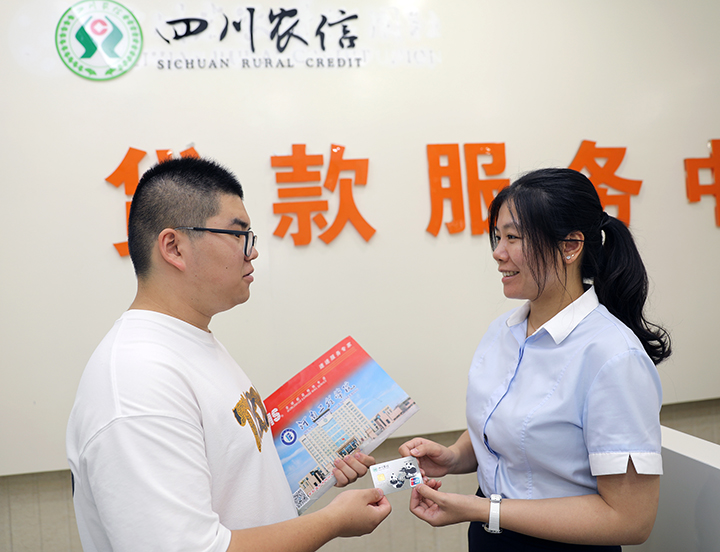 1696655070282772.jpg 丹棱農(nóng)商銀行東門(mén)支行工作人員快速為助學(xué)貸款學(xué)生辦好銀行卡 丹棱農(nóng)商銀行供圖.jpg