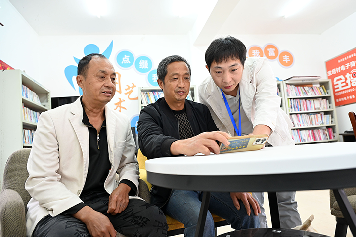 圖1  10月8日，內(nèi)江市東興區(qū)平坦鎮(zhèn)寶塔村，村便民服務(wù)站工作人員指導(dǎo)辦事群眾網(wǎng)上辦理有關(guān)事項(xiàng)。.png