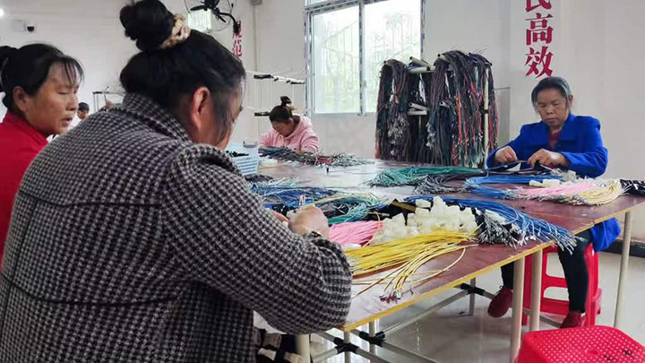 圖2 靈活就業(yè)人員在線束項(xiàng)目生產(chǎn)線上忙碌著.jpg