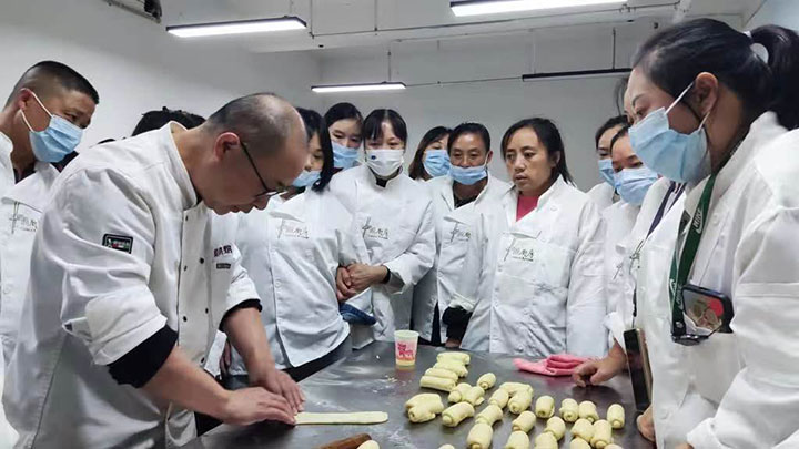 圖5 “桑工巧匠”靈活就業(yè)培訓(xùn)基地內(nèi)，老師向?qū)W員演示糕點(diǎn)制作技巧.jpg