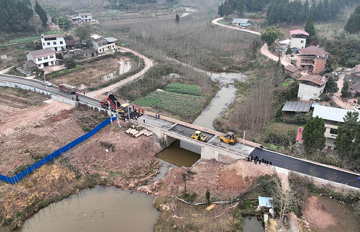 圖1  12月21日，內(nèi)江市東興區(qū)石子鎮(zhèn)天星村，筑路工人在石赤路鋪筑瀝青混凝土路面（無(wú)人機(jī)照片）。.jpg