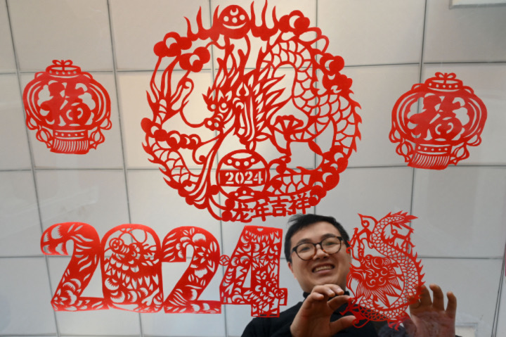 圖4  非遺傳承人李有生在展示自己創(chuàng)作的“龍年”主題剪紙作品.JPG