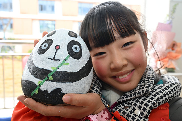 圖6  鵝卵石畫興趣班的學生正在展示自己的作品.jpg