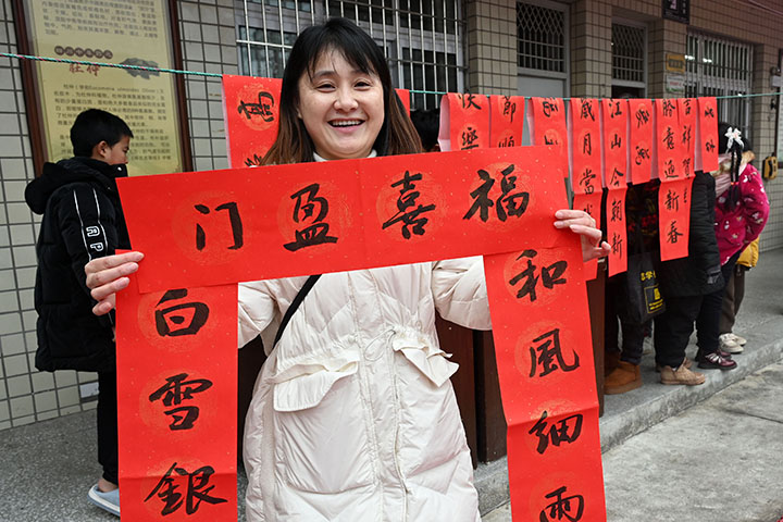 圖2  群眾喜領書法家義務書寫的春聯(lián).jpg