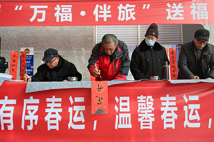 圖4  書法家在高鐵內(nèi)江北站義務(wù)為旅客書寫“?！弊趾痛郝?lián)，為廣大乘客送上新春祝福，溫暖旅客回家路。.jpg