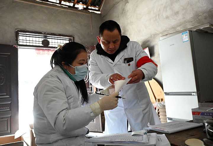 圖4  來自石子鎮(zhèn)衛(wèi)生院的“健康敲門”團隊成員查看體檢報告.jpg