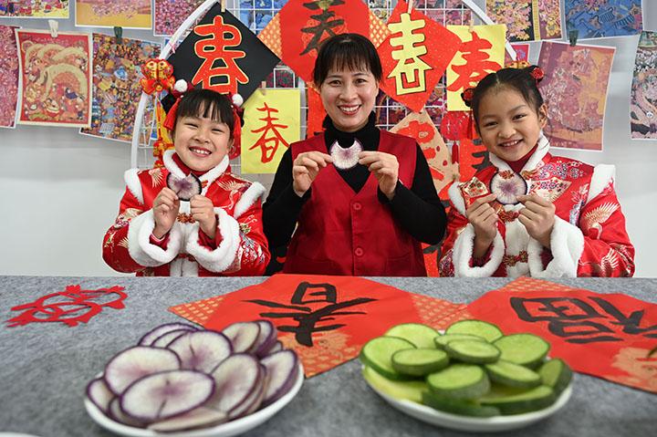 圖2 2024年2月2日，四川省內(nèi)江市東興區(qū)新時代文明實踐中心，小朋友在志愿者的帶領下體驗“咬春”習俗。.jpg