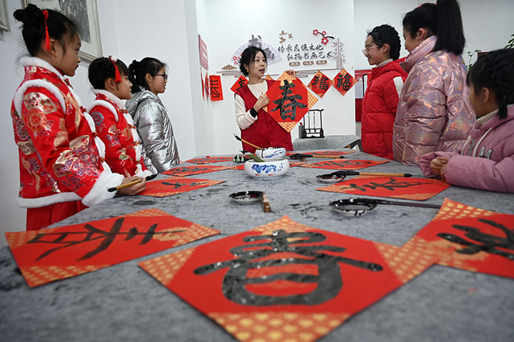 圖3  小朋友在志愿者的指導下書寫“春”字.jpg