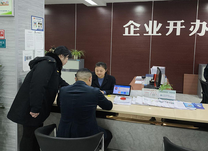 圖2  工作人員指導(dǎo)業(yè)主填寫小作坊生產(chǎn)許可證申請材料.jpg