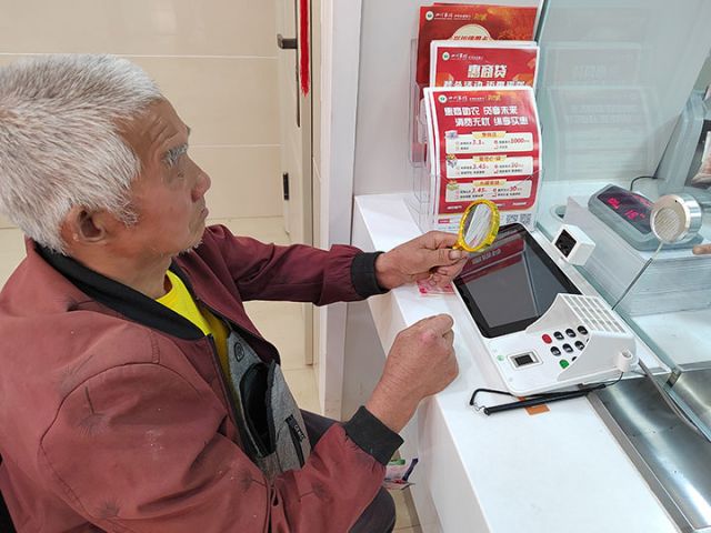 4老年人使用放大鏡更方便辦理業(yè)務(wù).jpg