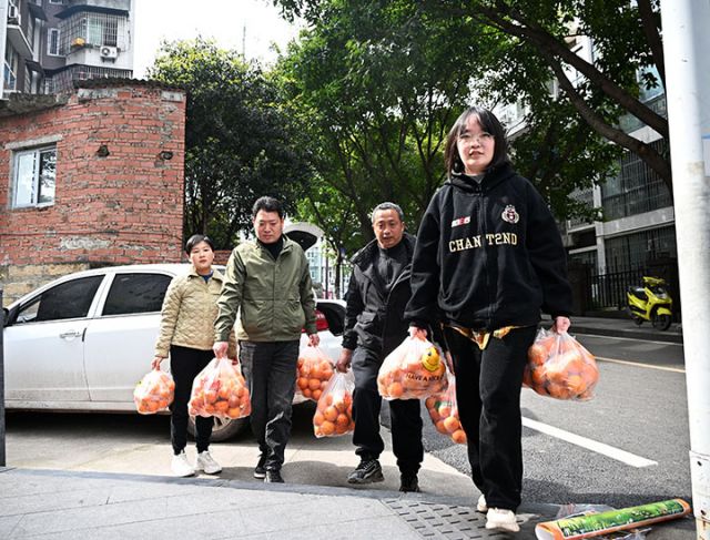 圖1  3月19日，內(nèi)江市東興區(qū)東興街道龍觀社區(qū)，來自川渝毗鄰的東興區(qū)平坦鎮(zhèn)與榮昌區(qū)清流鎮(zhèn)促銷團(tuán)隊(duì)成員正在轉(zhuǎn)運(yùn)沃柑和血橙。.JPG