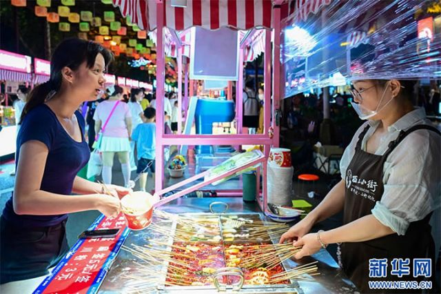圖2  7月10日，游客在洛陽(yáng)市西工小街選購(gòu)美食。.jpg