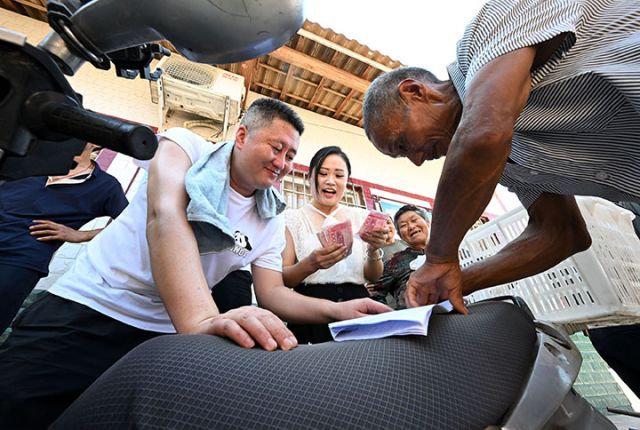 圖5  8月1日，四川省內(nèi)江市東興區(qū)高梁鎮(zhèn)慈花村，村民正在現(xiàn)金結(jié)算高粱銷售款。.jpg