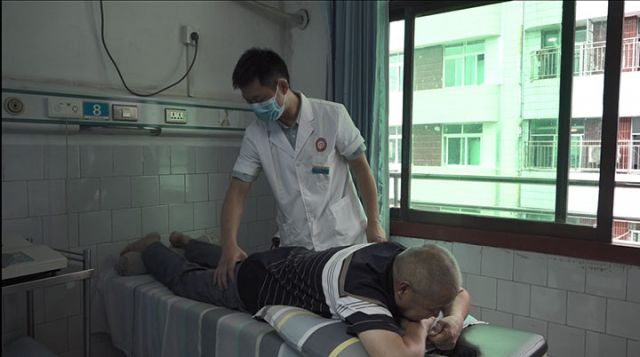 圖4  永清鎮(zhèn)中心衛(wèi)生院中醫(yī)館醫(yī)師正檢查患者身體狀況。呂敏 攝.jpg