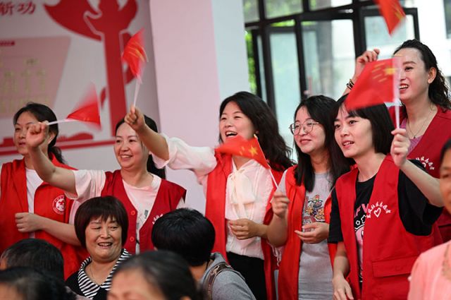 圖2  志愿者和當(dāng)?shù)馗刹咳罕姄]動著五星紅旗喜迎國慶，祝福祖國。.jpg