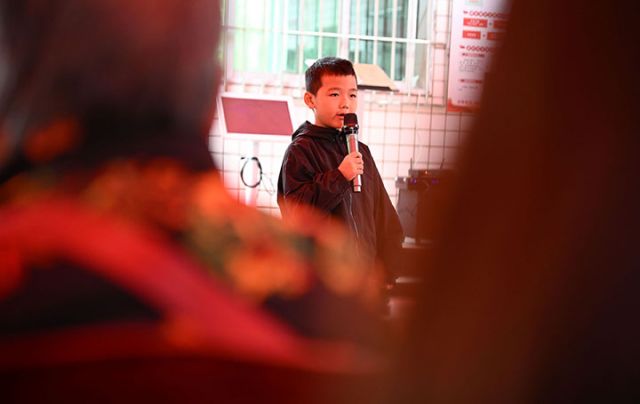 圖4  一名兒童正在為老人表演節(jié)目，以此促進(jìn)代際情感聯(lián)結(jié)，豐富老人精神世界。.jpg