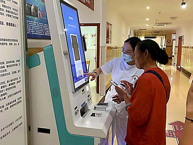 圖8  在安岳縣中醫(yī)醫(yī)院，醫(yī)護(hù)人員正在教患者線上辦理業(yè)務(wù)。劉芳蓮 攝.jpg